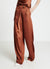 Pantaloni palazzo similsatin con piega asimmetrica